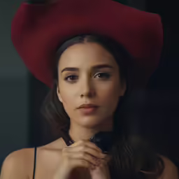 a woman wearing a red hat holding a camera