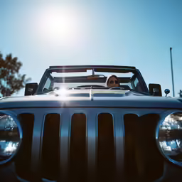 a person sits in the front passenger seat of a jeep