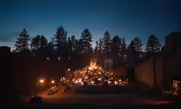 a group of firewood are lit by candles in the dark