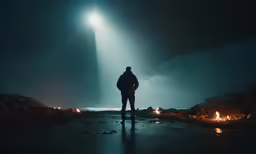 a person standing on the ground, with their back to the camera, looking out at the sky