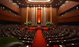 empty auditorium with bright red carpet and lots of chairs