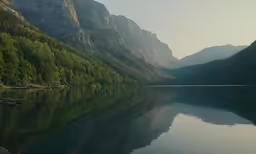 water is reflecting the mountains surrounding them in the lake
