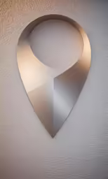 a large silver wall sculpture with a circular cut out