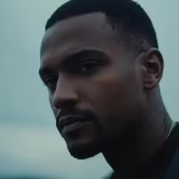 a close up shot of a man with black hair and a beard