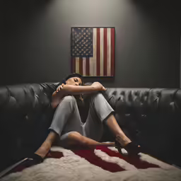 a woman sitting on top of a black couch