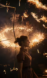 a woman wearing a dress while standing in front of a lot of fireworks