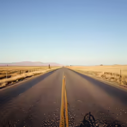 an empty road stretches into the distant horizon