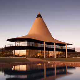 a large triangular building is lit up by the evening sun