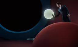 a man in suit and tie standing on large object