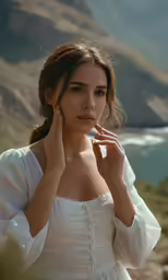 young woman in white dress near the ocean posing for a photo