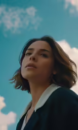 a woman in black with her head tilted into the sky