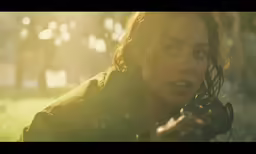 a woman holding a camera is looking at the ground