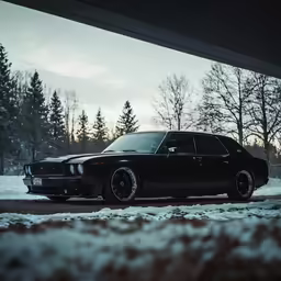 a black car parked next to a curb in the snow