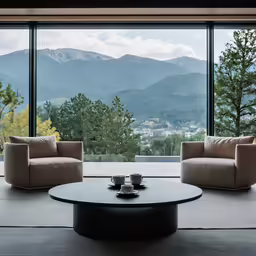 modern looking living room with big windows and mountain view