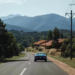 car driving down country road in the mountains