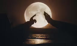 a man standing next to another man in front of the moon