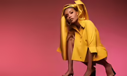 a woman wearing yellow, kneeling in a fashion photo