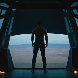 a man standing by a window with his arms crossed