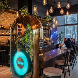 the bar at a restaurant is adorned with greenery