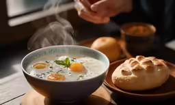 a person dipping their food into a bowl