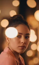 a woman with a frecky necklace looks at the camera