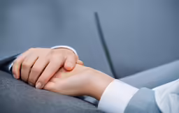 a close up shot of two people holding hands