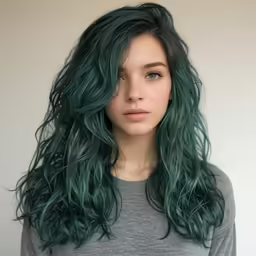 a woman with green hair with long curls