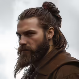 the male with a beard has a messy ponytail in the top knot
