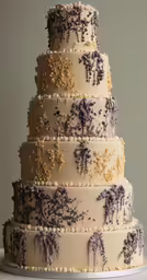 a three tiered cake with purple and yellow decorations