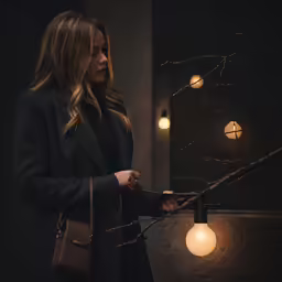 a woman holding a handbag and looking through a chain