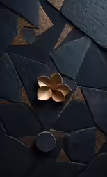 a gold flower sitting on top of a black surface