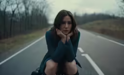woman sitting on the ground with a motorcycle