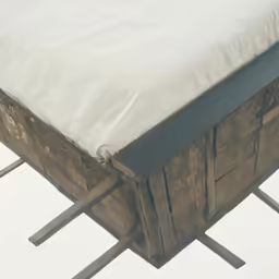 a wooden bench that has a mattress and pillow on top of it