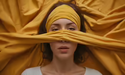 a woman with a yellow cloth covering her face