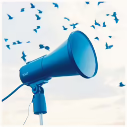 an up close shot of a blue speaker with birds flying in the air