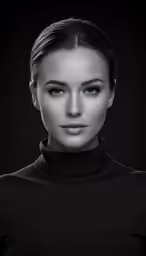a woman in black shirt standing against a dark background