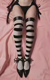a woman is laying down in black and white stockings