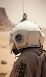 a nasa suit sitting on top of a sandy hill