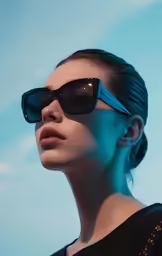 the woman wearing sunglasses is looking up into the sky