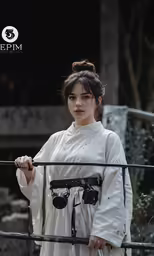 a woman in white holding a camera on a stick