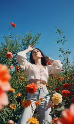 a woman standing in the middle of a field of flowers