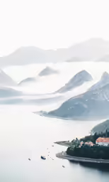 an aerial view of lake and mountains in the distance