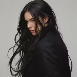 a young woman with long black hair in a black coat
