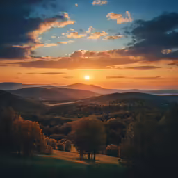 the sun rises over a hill with rolling hills in the background