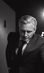a man in a suit looks down at something