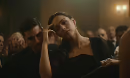 a man sitting next to a woman in a crowd