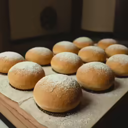 several rolls sit on top of a wooden serving tray