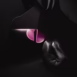 a black background with two boxing gloves and a pink ball