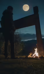 man standing by the fire in the forest