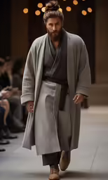 man in gray long outfit on runway with others